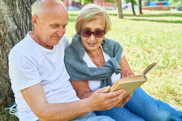 Älteres Paar, das draußen ein Buch liest
