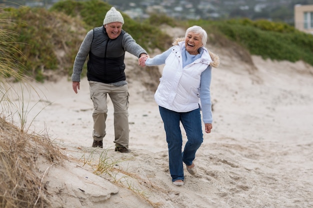 Älteres Paar, das Spaß zusammen am Strand hat