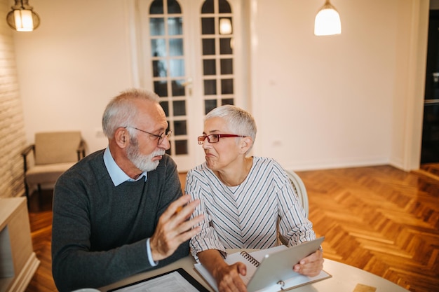 Älteres Paar, das zu Hause an seinen Finanzen arbeitet