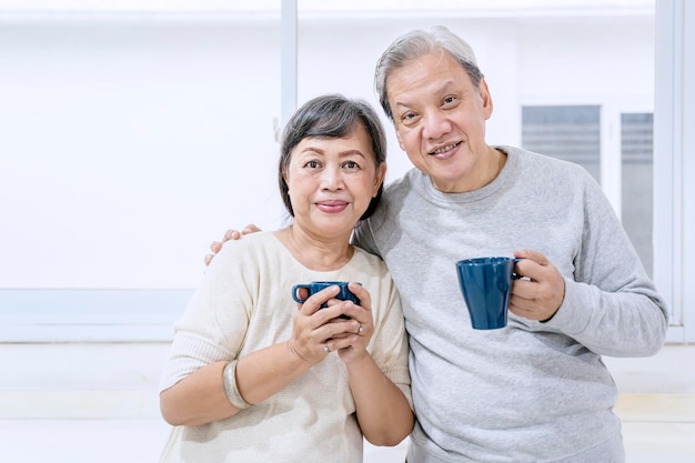 Älteres Paar, das zu Hause eine Tasse heißen Tee hält