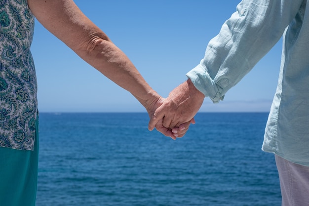 Älteres Paar Händchen haltend vor dem Meer, Horizont über Wasser. Schönheit der Natur