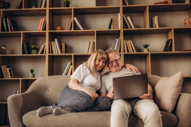 Älteres Paar mit einem Laptop-Computer zu Hause