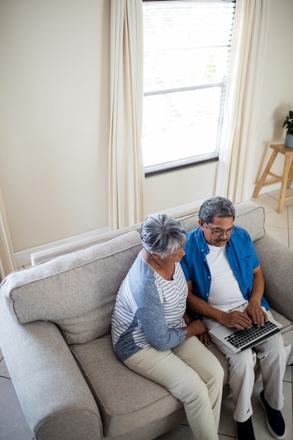 Älteres Paar mit Laptop im Wohnzimmer