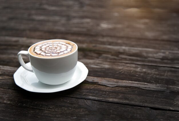 Último café en taza en mesa de madera