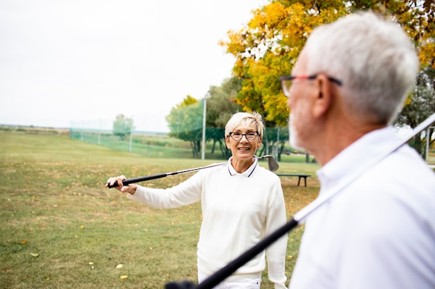 Último homem e mulher prestes a jogar golfe juntos e desfrutar da liberdade.