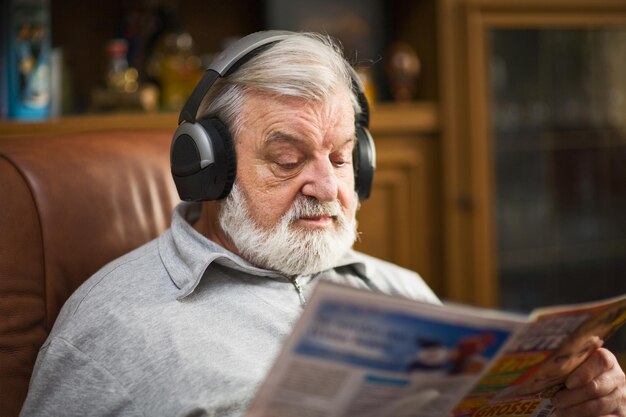 Último homem em casa usando fones de ouvido, lendo uma revista