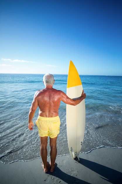 Último homem posando com uma prancha de surf