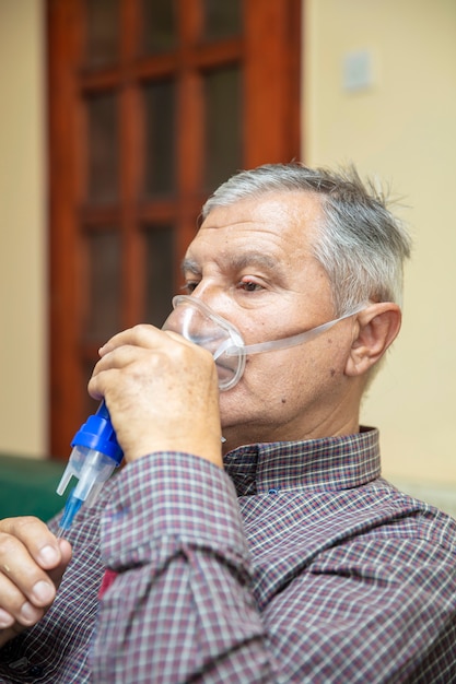 Último homem usando equipamento médico para inalação com máscara respiratória, nebulizador