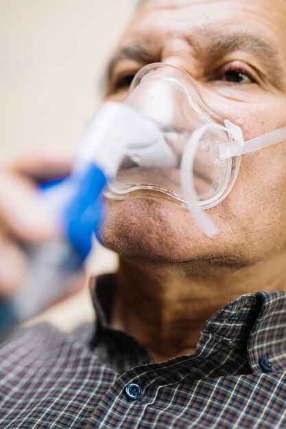 Último homem usando equipamento médico para inalação com máscara respiratória, nebulizador