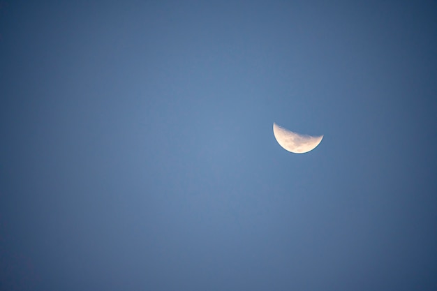 Lua à luz do dia no céu brilhante.