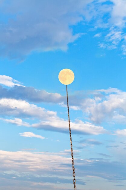 Foto lua cheia amarrada em corrente sobe no céu azul