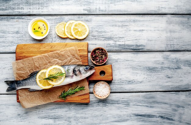 lubina pescado con limón y especias sobre fondo de madera