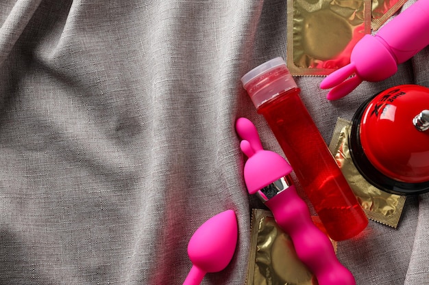 Lubricante en una botella roja con juguetes sexuales para texto