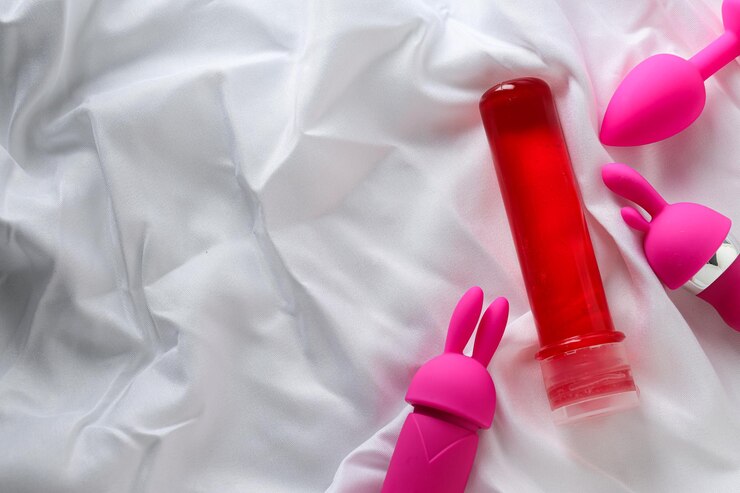 Lubricante en una botella roja con un vibrador y un tapón anal para texto