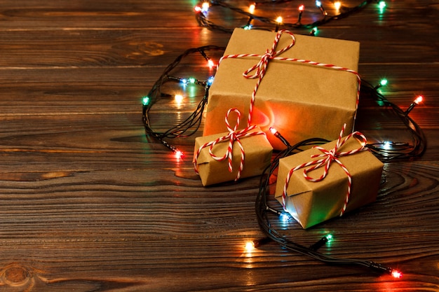 Luces de árboles de Navidad en el piso alrededor de un grupo de cajas de regalo bien envueltas colocadas debajo de un árbol de Navidad