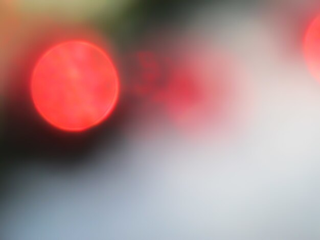 Luces de bokeh Defocused para círculos rojos de fondo de luz abstracta y fondo navideño