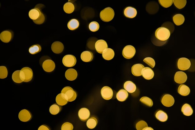 Las luces bokeh doradas crean un fondo festivo sobre un fondo negro