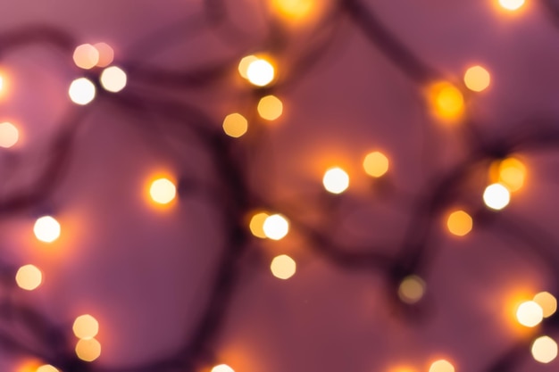 Luces bokeh festivas doradas sobre fondo rosa borroso Navidad o concepto de fiesta