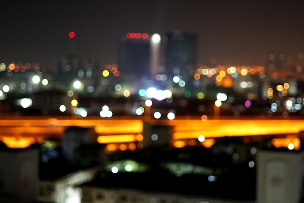 Luces de brillo de ciudad borrosa en el fondo de la noche