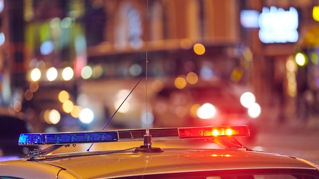 Luces de coche de policía en la calle de la ciudad de noche. Luces rojas y azules