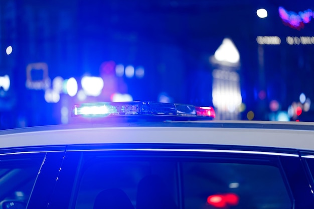 Luces de coche de policía por la noche en la ciudad con enfoque selectivo y bokeh