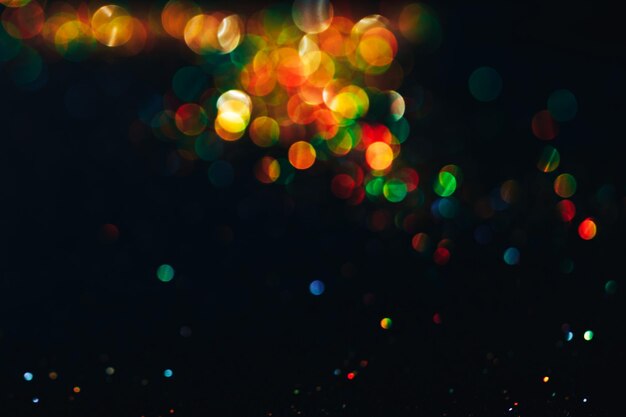 Luces de color bokeh destellos coloridos sobre fondos negros capa superpuesta