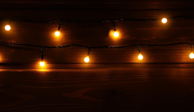 Luces de Navidad brillando sobre fondo de madera