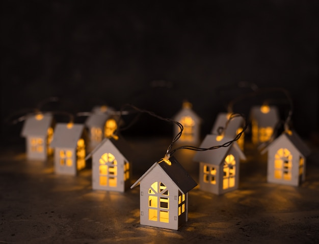 Luces de Navidad, guirnaldas en forma de casas de madera.