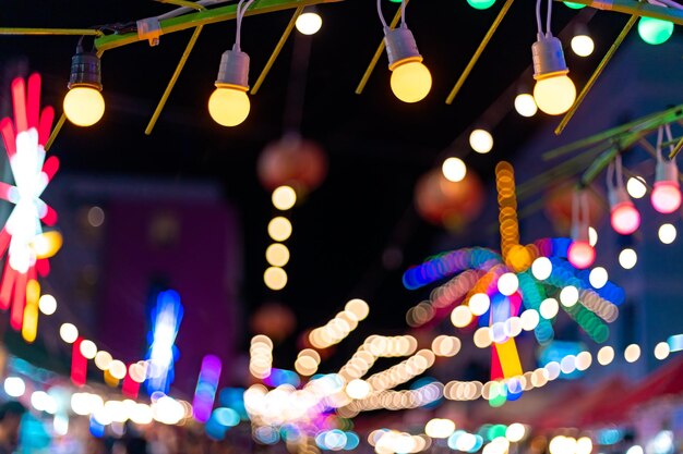 Foto luces de navidad iluminadas colgando al aire libre por la noche