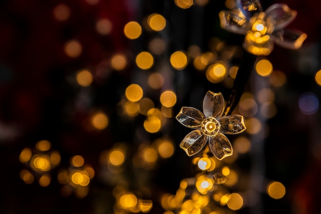 Luces navideñas en forma de flor con luces borrosas en el fondo