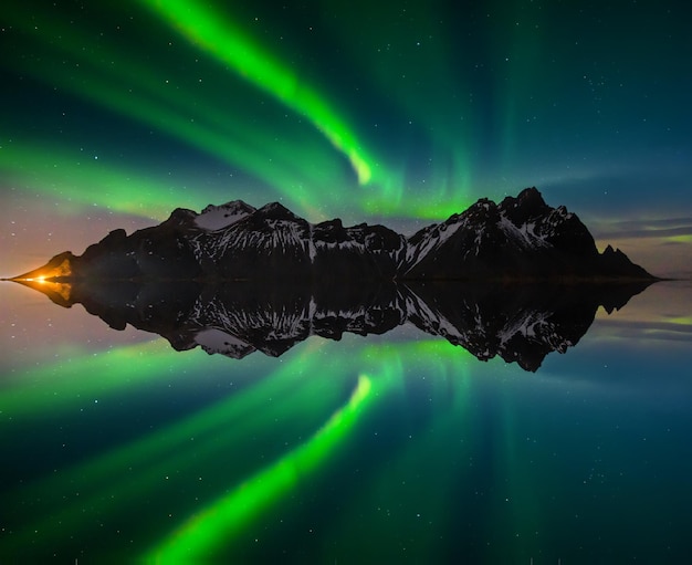 Luces del norte en la montaña Vestrahorn y la playa de Stokksnes Islandia