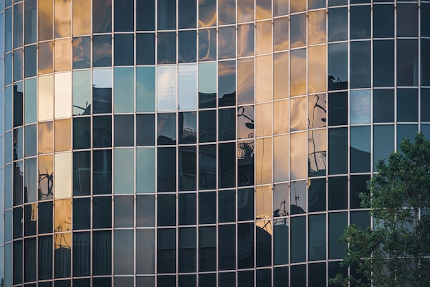 Las luces de la tarde se reflejan en la fachada de vidrio curvo de un edificio de oficinas
