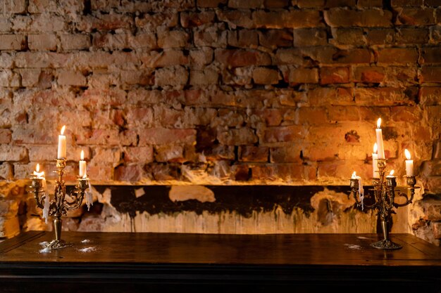 Luces de velas elegantes contra una pared de ladrillo rústica