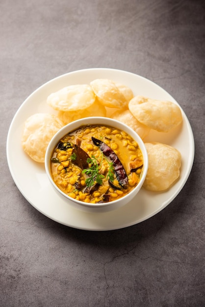 Luchi Cholar Dal oder gebratenes Brot aus Mehl, serviert zusammen mit Curry-Chana oder Bengal-Gramm