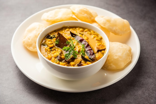 Luchi Cholar Dal oder gebratenes Brot aus Mehl, serviert zusammen mit Curry-Chana oder Bengal-Gramm