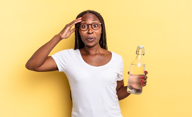 Luciendo feliz, asombrado y sorprendido, sonriendo y dándome cuenta de buenas e increíbles noticias. concepto de botella de agua