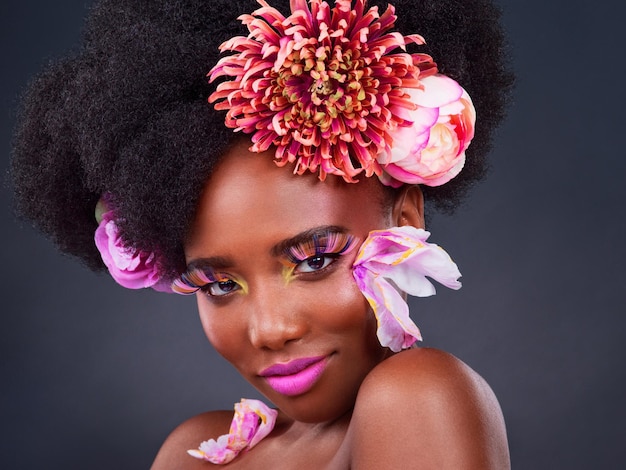 Luciendo fresco y en su mejor foto de estudio de una hermosa joven posando con flores en el pelo