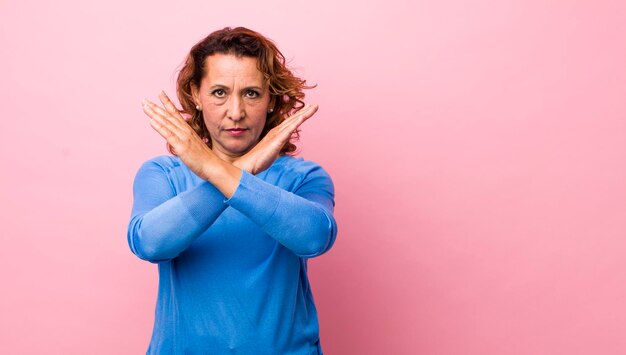 Luciendo molesto y harto de tu actitud diciendo basta de manos cruzadas al frente diciéndote que te detengas