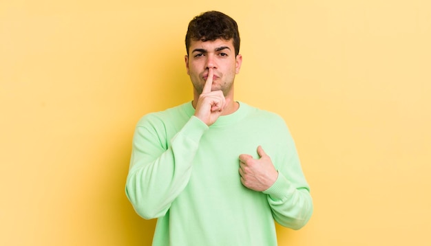 luciendo serio y enfadado con el dedo presionado en los labios exigiendo silencio o silencio manteniendo un secreto