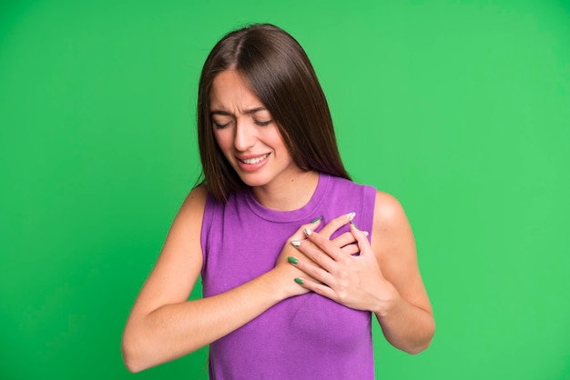 Luciendo triste, herido y con el corazón roto sosteniendo ambas manos cerca del corazón llorando y sintiéndose deprimido