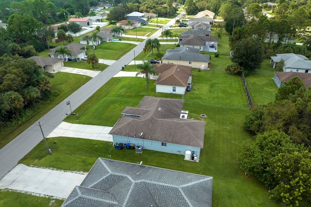 Luftansicht auf eine kleine Stadt in Amerika, eine Vorstadtlandschaft mit Privathäusern zwischen grünen Palmen in einer ruhigen Wohngegend in Florida