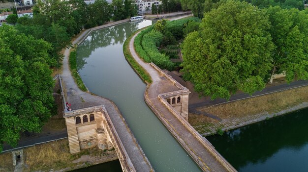 Luftansicht des Flusses, des Kanals du Midi und der Brücken von oben, Stadt Beziers, Südfrankreich