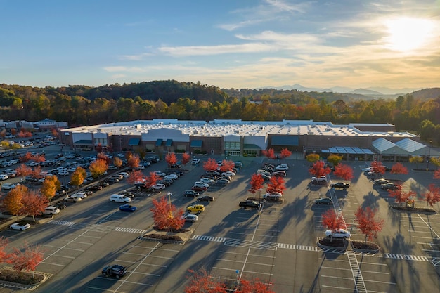 Luftansicht des großen Parkplatzes vor dem Rgocery-Laden mit vielen geparkten farbenfrohen Autos Parkplatz im Supercenter Einkaufszentrum mit Linien und Markierungen für Fahrzeugplätze und Richtungen