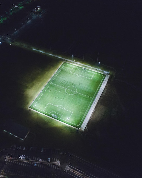 Luftansicht eines beleuchteten Fußballfelds bei Nacht