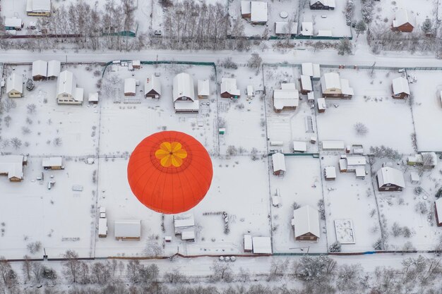 Luftansicht eines Heißluftballons über einem schneebedeckten Feld
