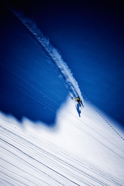 Foto luftansicht eines mannes, der auf einem schneebedeckten berg ski fährt