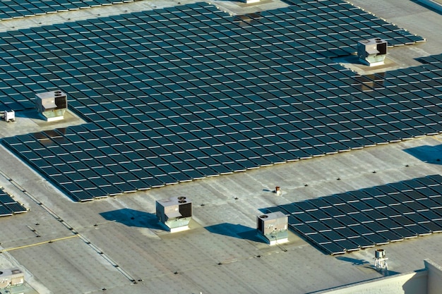 Foto luftansicht eines solarkraftwerks mit blauen photovoltaikplatten, die auf dem dach eines industriegebäudes montiert sind, um grünen, ökologischen strom zu erzeugen.