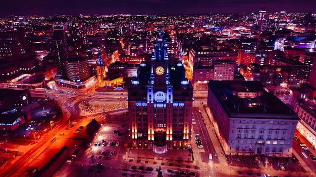 Luftansicht nachts von einem Stadtbild mit beleuchteten Gebäuden und Straßen, die städtische Architektur und das lebendige Stadtleben in Liverpool, Großbritannien, zeigen