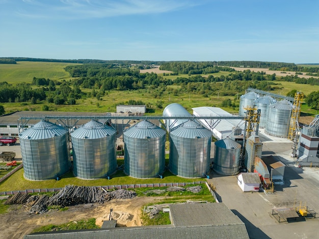 Foto luftansicht silos aus silber in einer landwirtschaftlichen fertigungsanlage für die verarbeitung, trocknung, reinigung und lagerung von landwirtschaftlichen erzeugnissen mehl, getreide und getreide große eisenfässer mit getreide