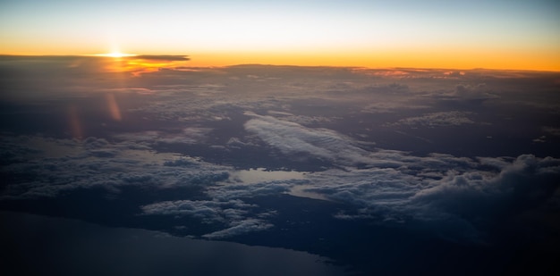 Luftaufnahme aus dem Flugzeug zum Sonnenuntergang über dem Ufer